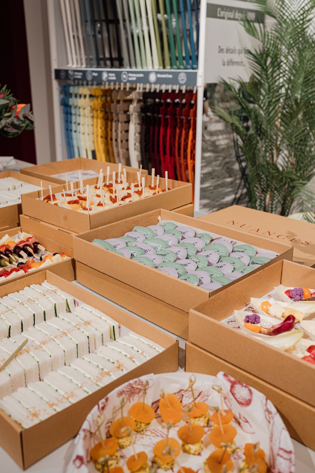 Plateaux de catering avec assortiments de sandwiches, mini burgers, brochettes de légumes et biscuits dans une présentation soignée.